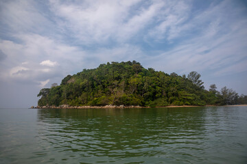 Small island with palm trees in the sea. Colorful turquoise water. Summer day. Beautiful nature.