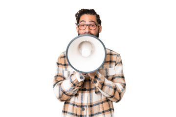 Young man with beard over isolated chroma key background shouting through a megaphone