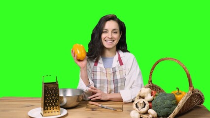 Happy young woman going to cook, holding pepper on the chroma key