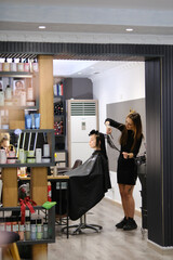 Hair stylist working in a salon. Blurred image for background