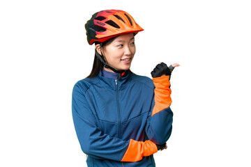 Young cyclist woman over isolated chroma key background pointing to the side to present a product