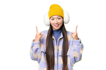 Young Asian woman wearing winter muffs over isolated chroma key background pointing up a great idea