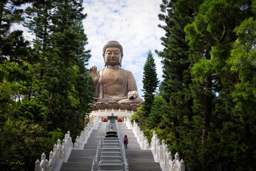 a large buddha statue on top of steps in a park