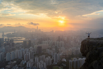 person on the edge of the cliff above cityscape