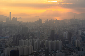 Fototapeta premium Towering urban metropolis lining the coast, backed by scenic hills in Hong Kong during the sunset