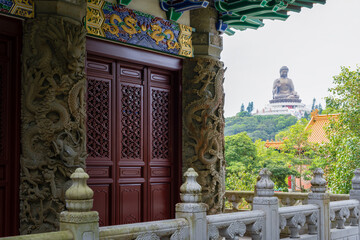 a building with a large statue in the background on a hill side