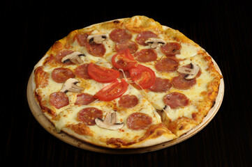 Pizza with mozzarella cheese, ham and mushrooms on wooden table