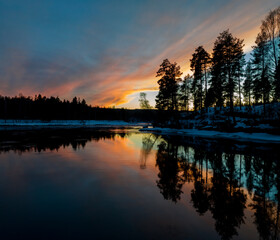 Obraz premium Serene lake illuminated by a vibrant sunset