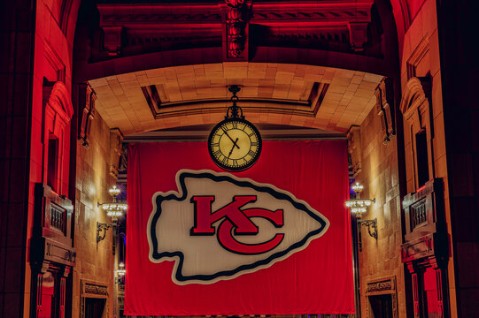 an indoor event with a large chiefs logo sign and a clock on it
