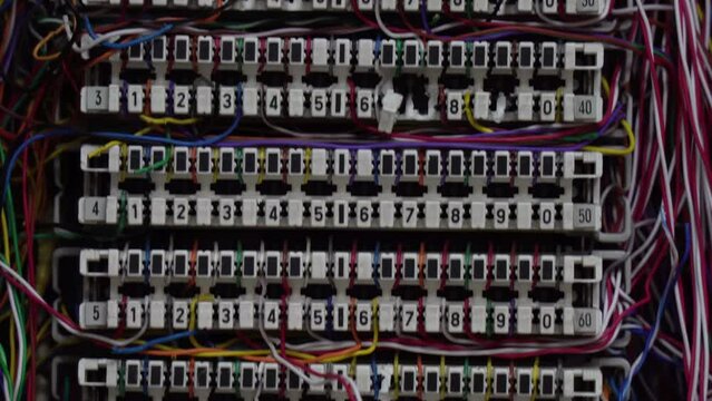 Inside a PABX telephone booth that has a number of connecting cables in many colors in the analog system. communication technology
