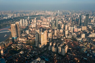 The central urban area of Wuhan in the morning light, towering buildings are surrounded by mist.
