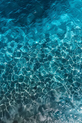 waves of H2O, crystal clear blue water of the sea, with ripples on its surface and the sunlight shining through them and reflecting in their shimmering light, photorealistic // ai-generated 
