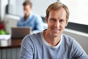 Naklejka premium Man, employee and happy in office on portrait for career or job growth and opportunity as graphic designer. Proud, smile and confident in startup company or business with creativity in digital agency