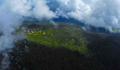 Aerial landscape with clouds over mountains and forests