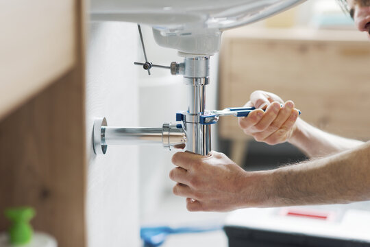 Professional plumber fixing a bathroom sink