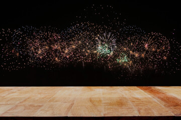 Empty wooden table top with fireworks background symbolizes celebration and happiness. For product...