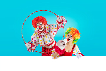 Funny clown looking through hula hoop in the circus, woman entertainer as Joker in a suit and wig,...