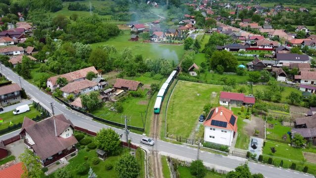 Aerial footage of the Sovata narrow gauge train passing through the houses