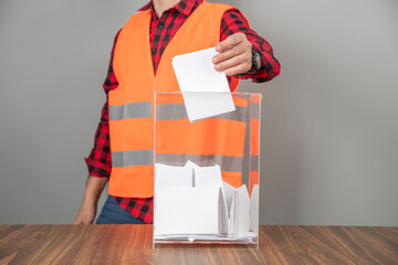 A voter casting a ballot into a ballot box on election day. Referendum, democracy,  plebiscite,...