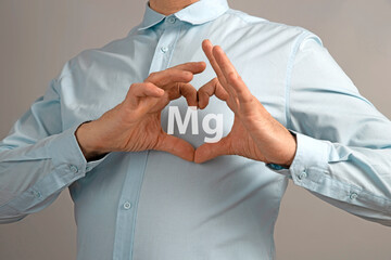 Mg, magnesium microelement concept. Heart-shaped palms on the chest. Heart shaped hand gestures
