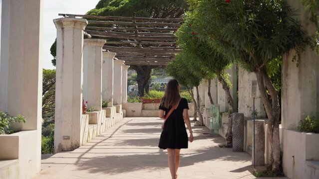 Beautiful design of a corridor with marble pilars with trees and plants on a sunny day