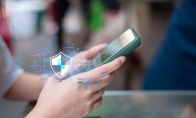 Close-up of a hand holding a smartphone with a digital security shield icon overlay, emphasizing...