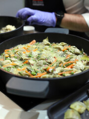 chef cooking a vegetable stew in a casserole