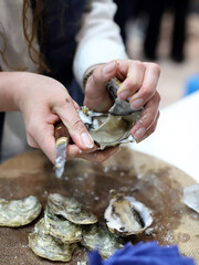expert chef opening oysters with hands and a serving knife
