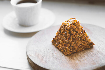 Cup of coffee and a piece of cake on a wooden board