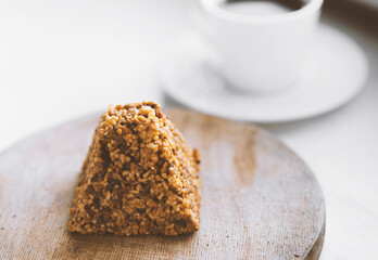 Cup of coffee and a piece of cake on a wooden board