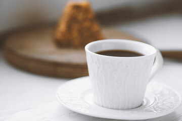 Cup of coffee and a piece of cake on a wooden board