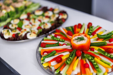 Decorated sliced vegetables as a buffet plate for a festive event. Peas in the pod, radishes and peppers with dip as an appetizer