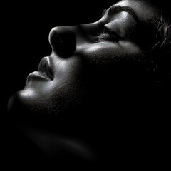 Dramatic black and white portrait of a woman’s face in profile, showcasing deep shadows and high contrast, highlighting her serene expression