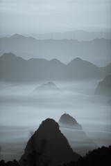 Image of Vertical drone shot of silhouettes of green-covered hills in mist at sunset, cool for background printed on Printed Glass Basin Splashbacks