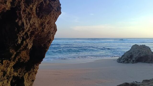 Landscape view of sea sand and coral rocks on a sunny summer day in the afternoon. Molang Beach, Tulungagung, Indonesia