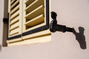 Closeup shot of a vintage iron figure on the wall next to the window.