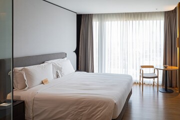 A large white bed with a white comforter and pillows