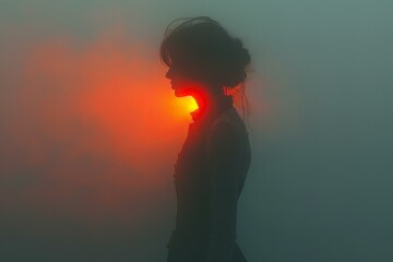 A woman standing in the fog with her red light shining
