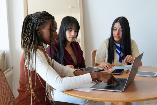 Three diverse women collaborating on a project at home