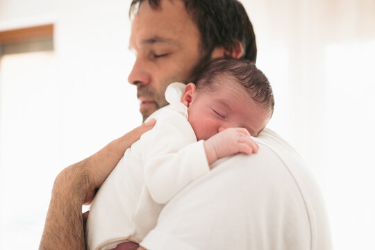 Newborn Baby Sleeping Peacefully in Father's Embrace