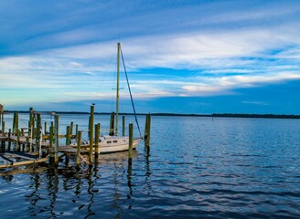 Scenic view of a marina featuring a wooden dock and sailboat tied to it