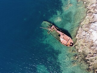 Small wooden boat floating in clear water near the beach