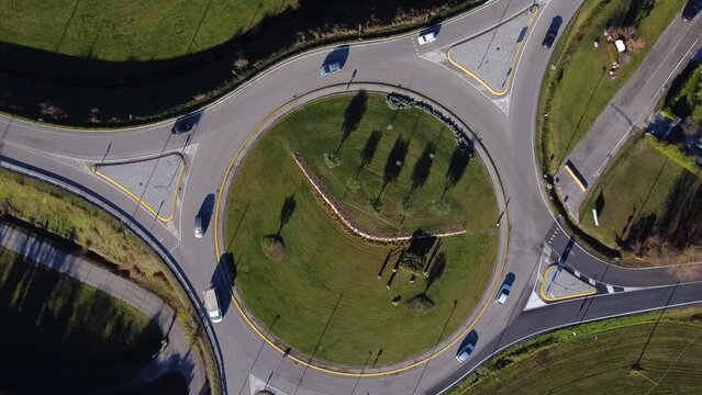 Aerial view of cars driving in a public square on a sunny day