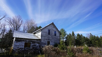 Aged, dilapidated house standing in a remote, wooded area