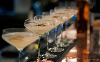 Assortment of colorful alcoholic beverages served in glasses on a bar countertop