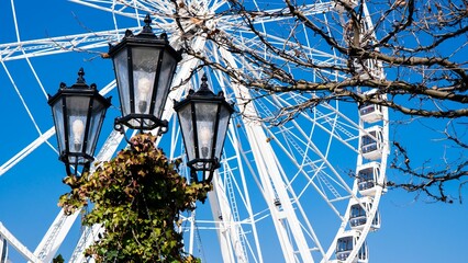 Street lamp with white ferries wheel in bg, ideal for summertime visuals