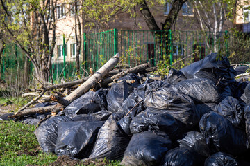 Heap of black garbage bags piled near residential buildings