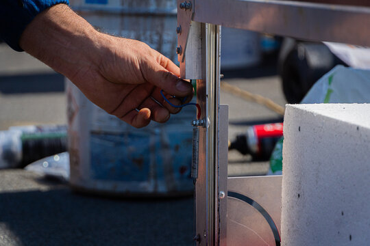 Hand of worker reparing tool on building site closeup. Heat cutting tool.
