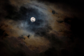 Moon in dark sky with clouds