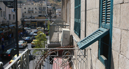 A balcony of an old house overlooking a commercial street in the downtown area of Amman